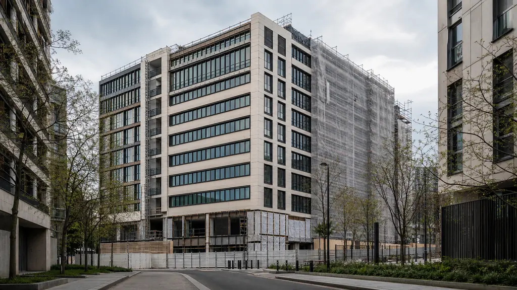 Contemporary Arc de Seine office building at 22-34 avenue Pierre Mendès France in Paris, viewed between rue Paul Klee and rue Fulton, showing its nine-story facade during architectural rehabilitation, editorial photography, no text, no logos